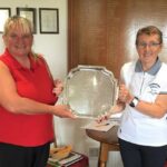Lindsay Garrett receiving the championship trophy from lady captain Mary Wilson.