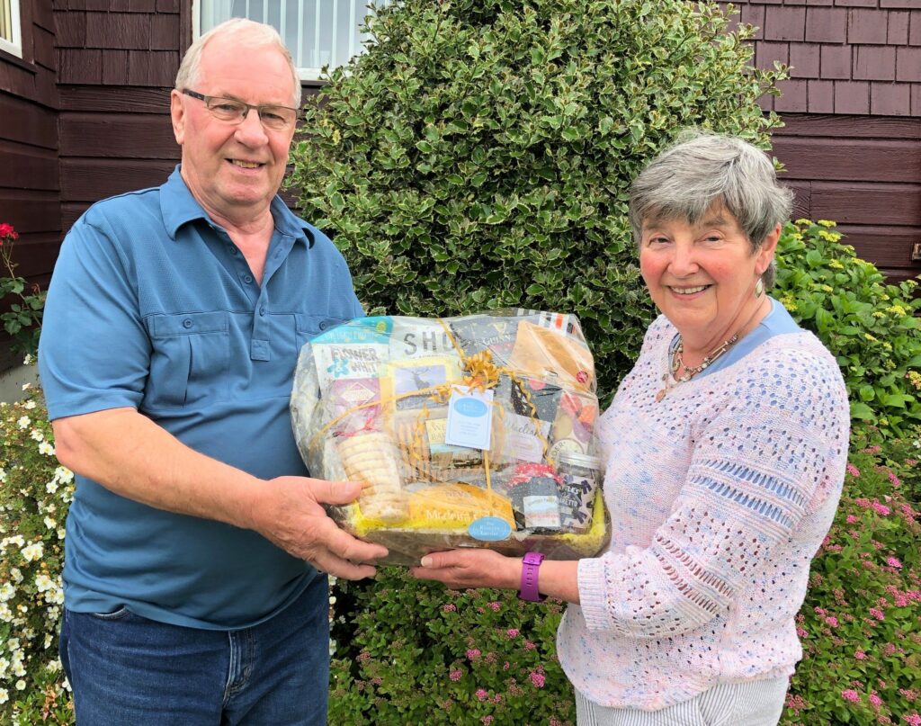 Campbeltown Community Council convener Valerie Nimmo, right, presents quiz winner Iain McMillan with his prize.