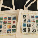 The tote bags feature 18 local landmarks on one side and 20 business sponsors on the other.