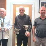 George MacMillan, winner of the seniors and championship trophies, centre, with handicap winner Stuart McAlister, left, and club captain Donald Brown, right.