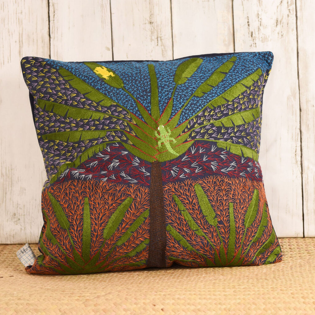 embroidered cushion with tropical plants and a lizard