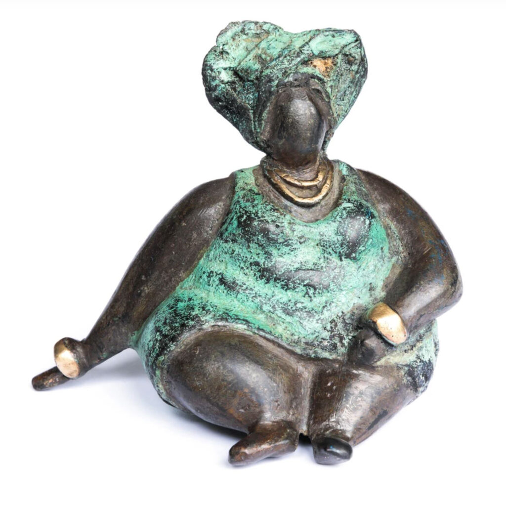 Bronze statue of plump black woman seated, wearing green dress and headscarf