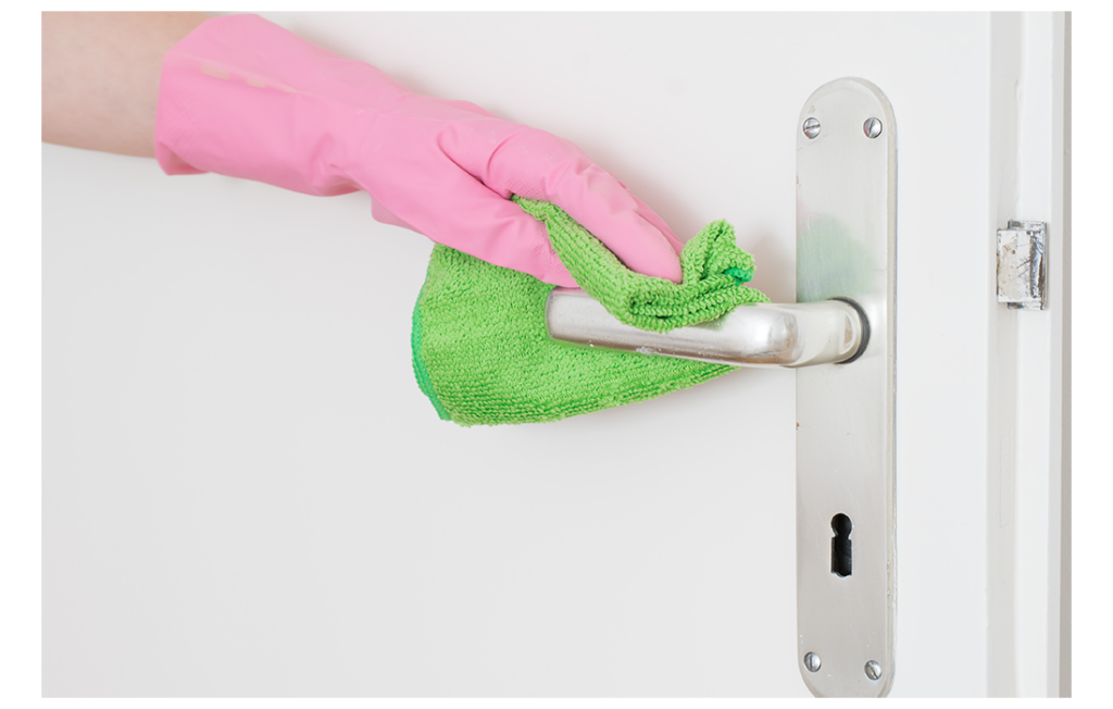 Hand in pink rubber glove cleaning doorhandle