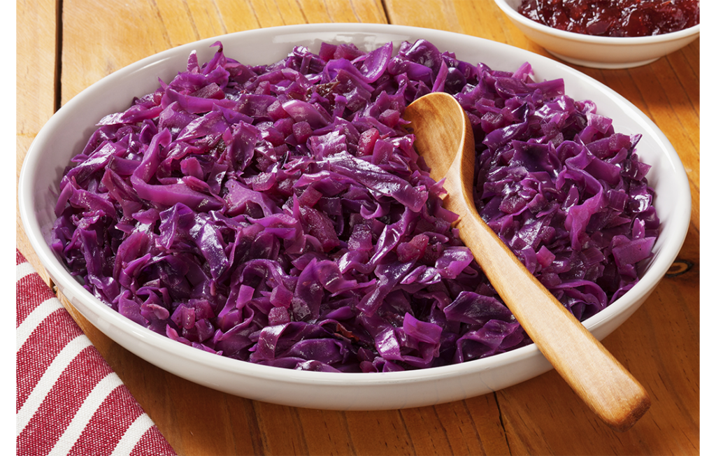 Red cabbage in big bowl with wooden spoon