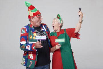 Mature couple in silly costumes for Elf Day, taking a selfie