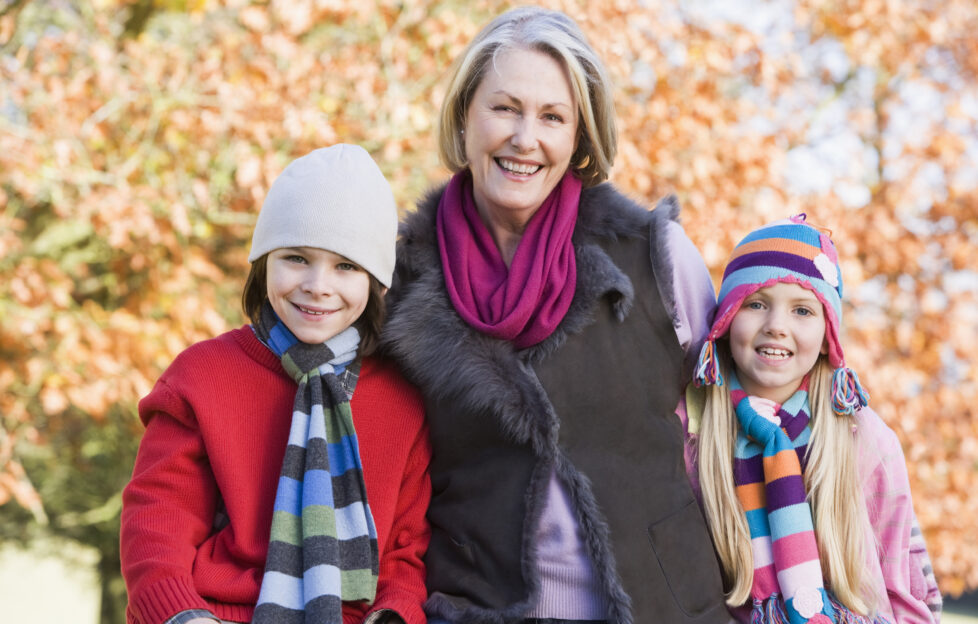 Grandmother and grandchildren on autumn walk;