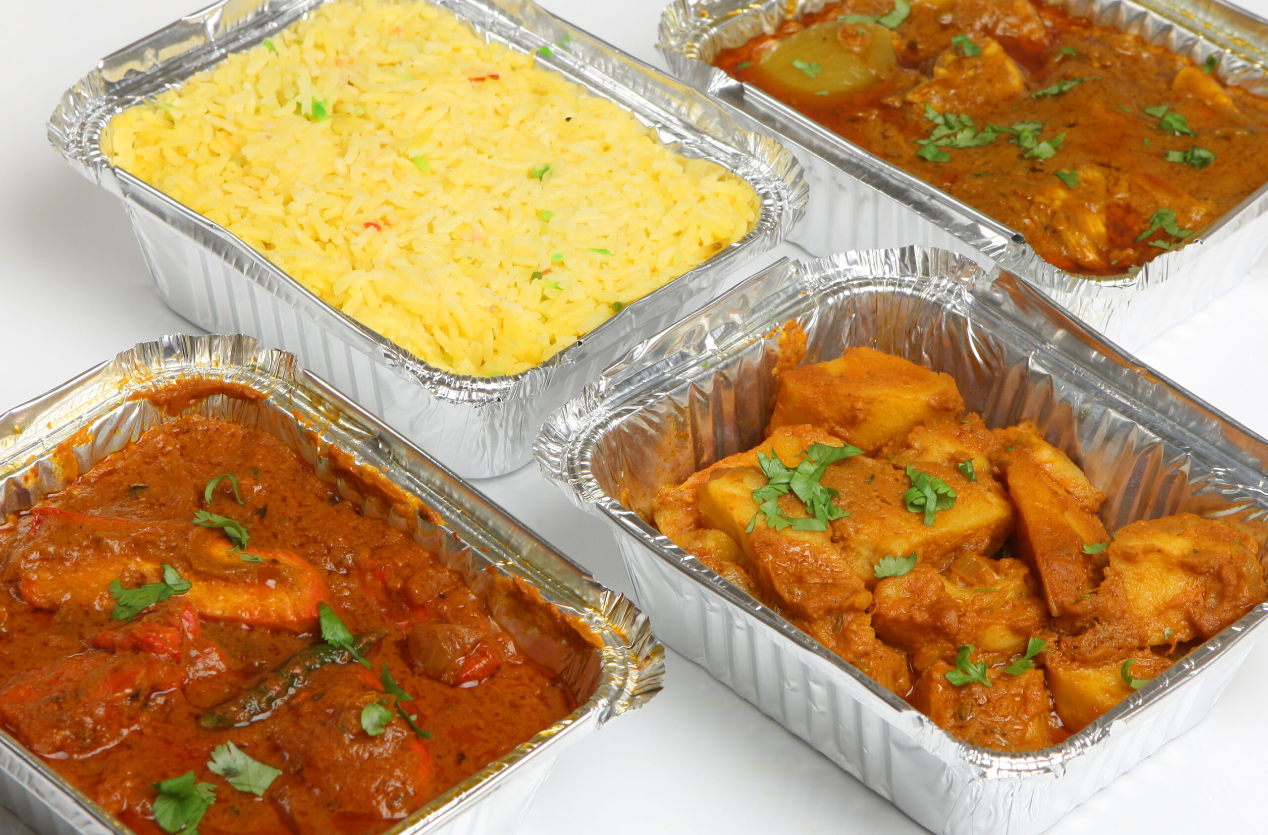 Indian takeaway food selection in foil containers.;