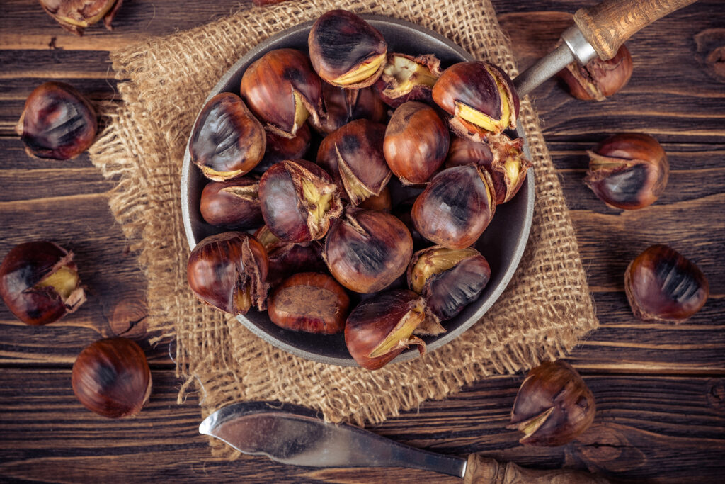 chestnuts in a pan on a wooden background; 