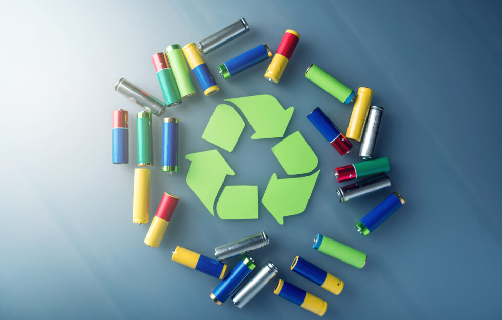 Used AA and proper disposal of toxic to the environment and soil batteries on a blue background. The concept of technologies of processing of harmful and recycling substances for ecological