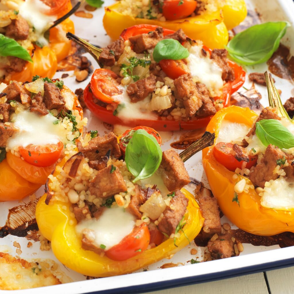 Dish of juicy stuffed peppers with cherry tomatoes and melted cheese