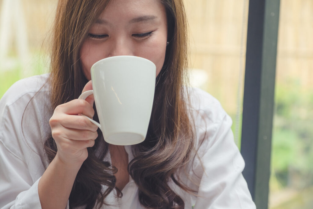 Woman taking sip from white mug