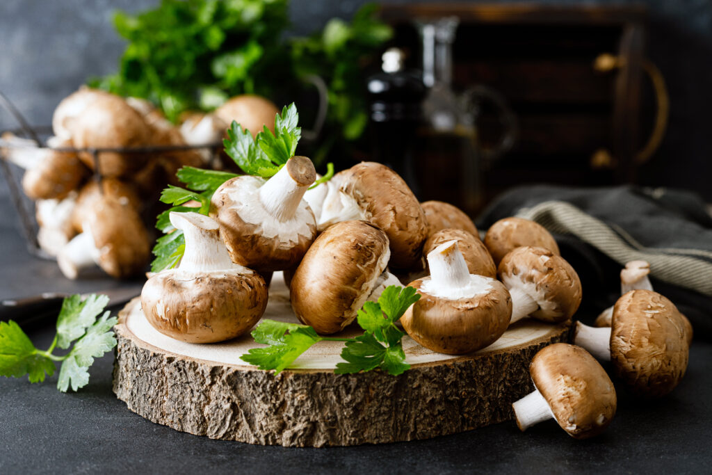 Raw mushrooms champignons on black background, cooking fresh champignons ;