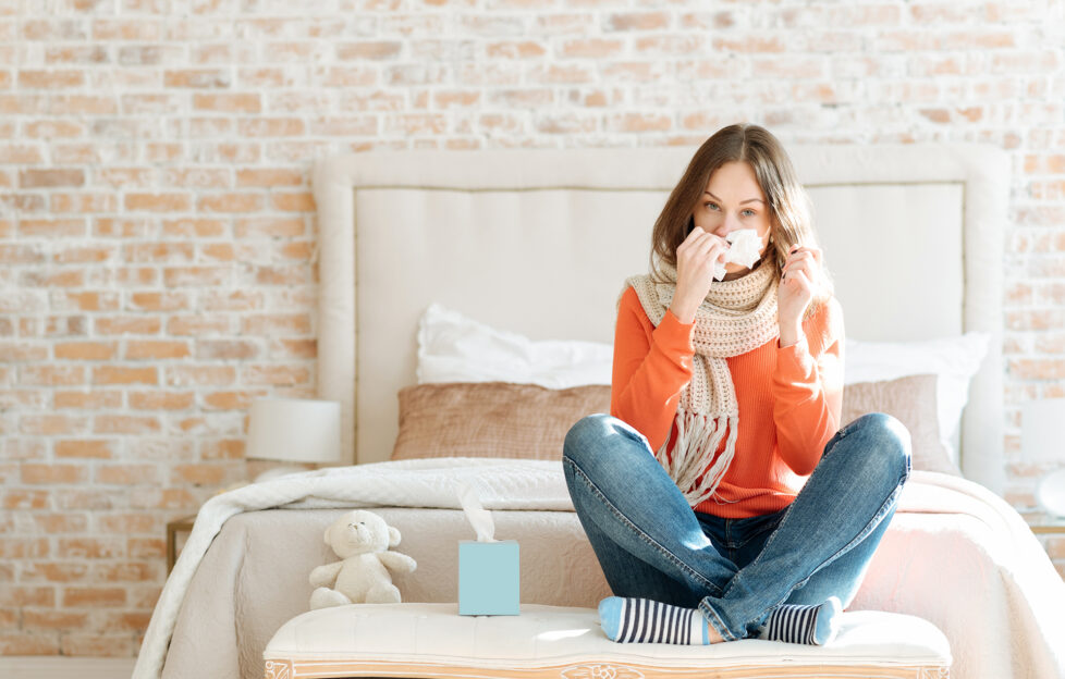 Upset young woman suffering from influenza at home;