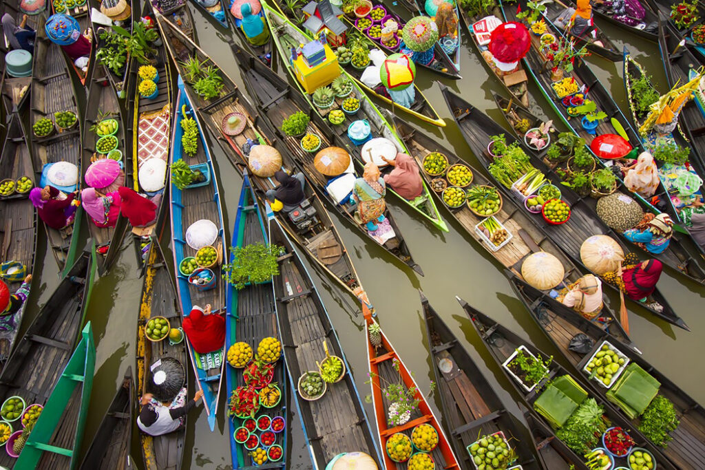 Locals gather to buy and sell fresh fruit, vegetables and spices at a floating market in Banjarmasin, Indonesia - captured by Abdul Gapur Dayak.