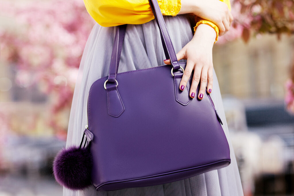 Lady with hand on purple handbag Pic: Shutterstock