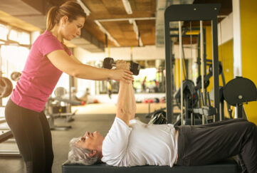 personal trainer working exercise with senior woman in the gym.