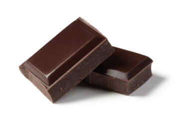 Two pieces of dark chocolate balanced against each other