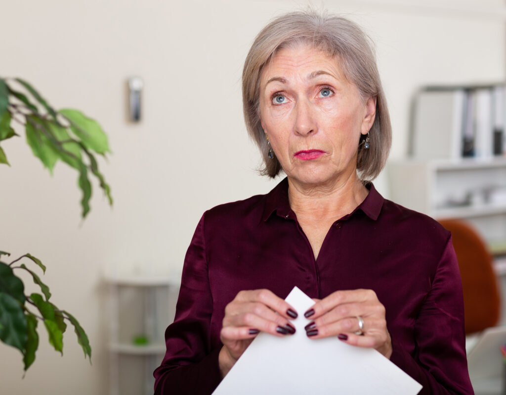 Worried mature woman holding letter