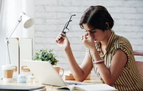 Stressed or tired business lady rubbing her eyes;