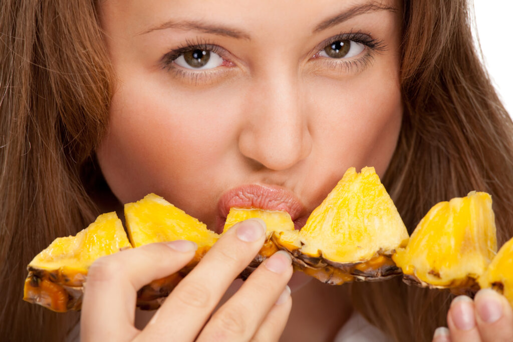 Woman eating a pineapple