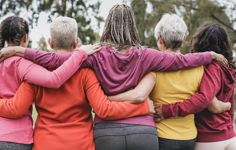 women hugging, back view, running club, multi-ethnic friends