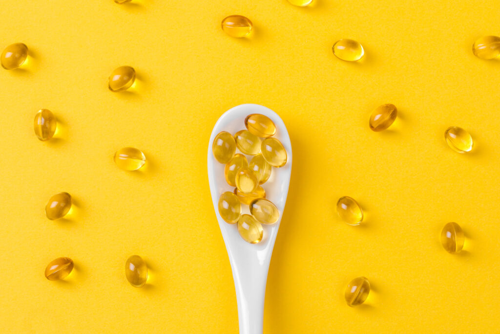 Close up of  oil filled capsules on spoon suitable for: fish oil, omega 3, omega 6, omega 9,  vitamin A, vitamin D, vitamin D3, vitamin E 