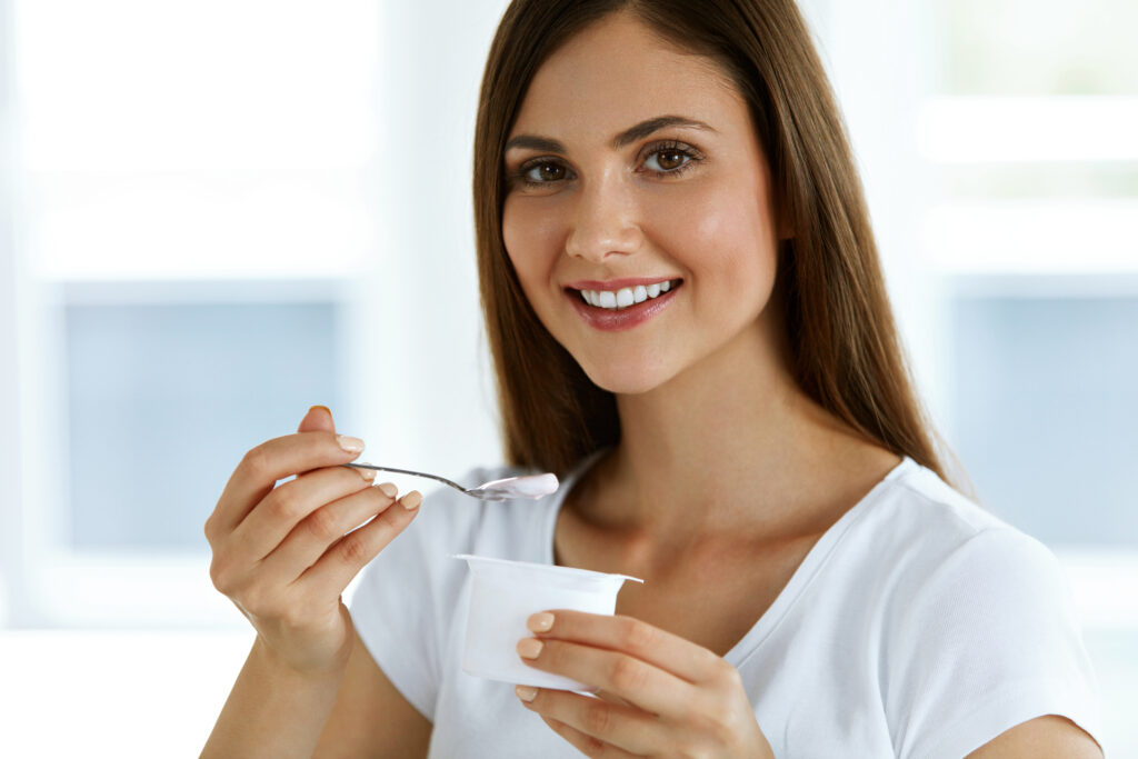 Healthy Lifestyle. Portrait Of Beautiful Sexy Smiling Woman Tasting Fresh Organic Yogurt. Charming Cheerful Girl On Diet Nutrition Eating Delicious Natural Yoghurt, Dairy Food.