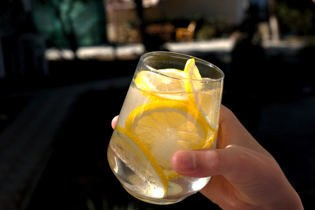 A fresh cocktail made with ginger beer, lime and ice. Drink in hand. 