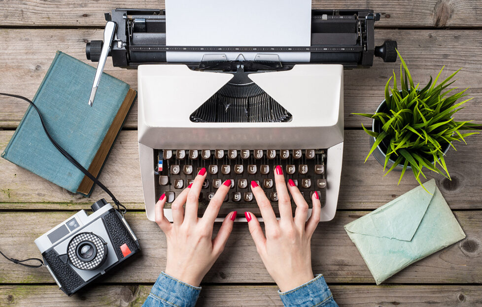 Hands typing on a typewriter