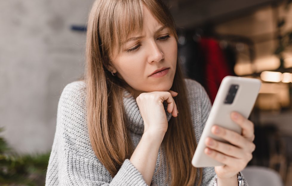 Lady looking a phone, confused Pic: Shutterstock