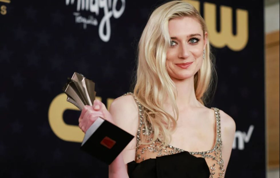 Elizabeth Debicki has won the best supporting actress in a drama series, for her role in The Crown. Image shows the actress holding up the award on the red carpet, she's wearing a sparkly gown and now has long blonde hair.