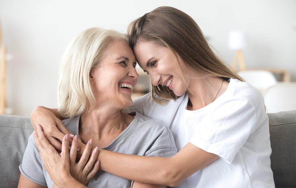 A younger woman hugging an older woman at home