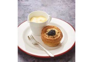 Sweet yorkshire pudding with apple, blackberry and syrup