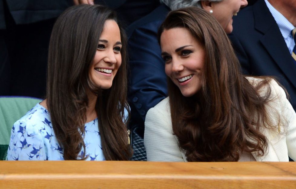 Celebrity siblings. Kate and Pippa Middleton whispering and smiling at a tennis game