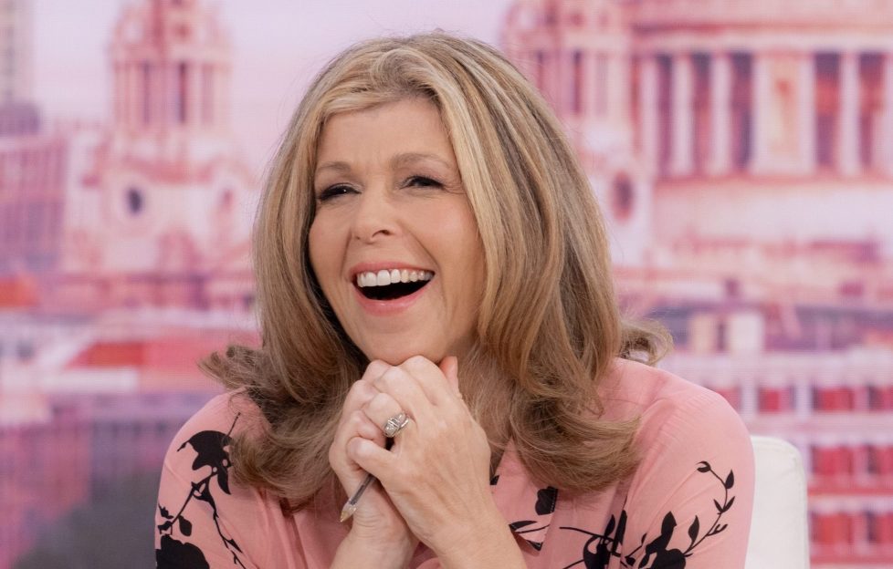 This is Your Life Kate Garraway possible new host of iconic reboot. Image features Kate on Good Morning Britain. She's smiling wide and resting her chin on her hand. She's wearing a pale pink blouse with black floral decoration.