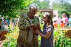 Dame Judi Dench and school pupil, Charlotte, posing for photos with the Sycamore tree seedling at Chelsea Flower Show.