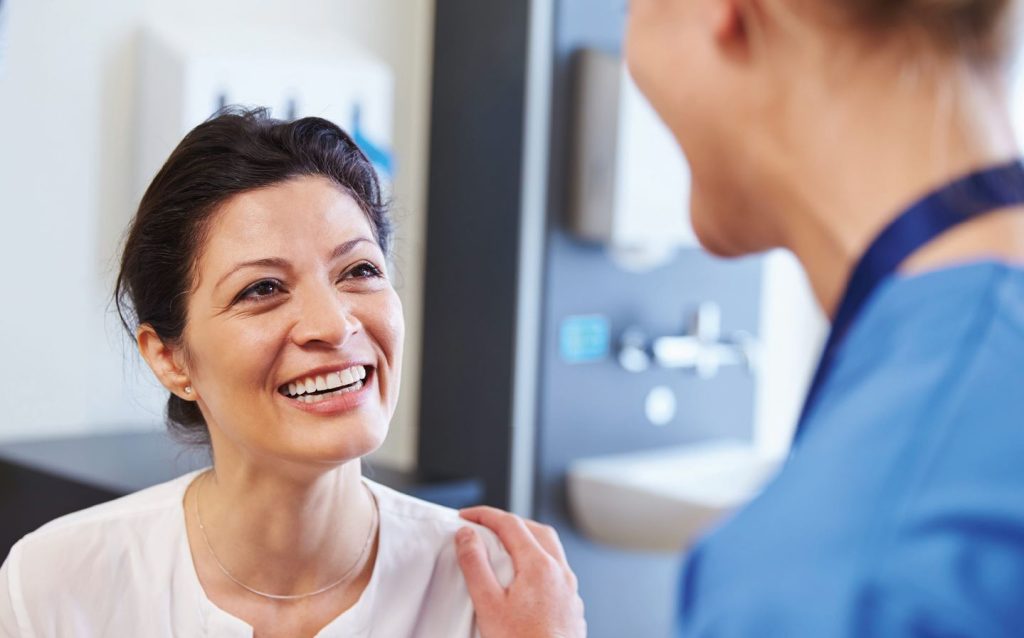 A doctor speaking to a woman patient about breast cancer