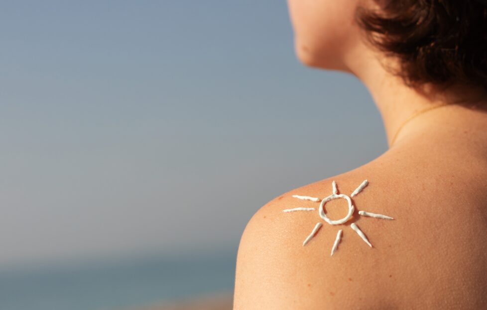 woman with sunscreen on shoulder in the shape of a sun