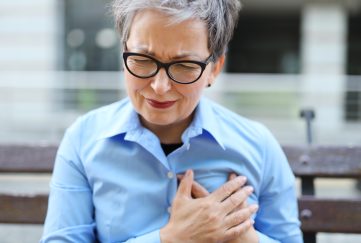 Older woman clutching chest.