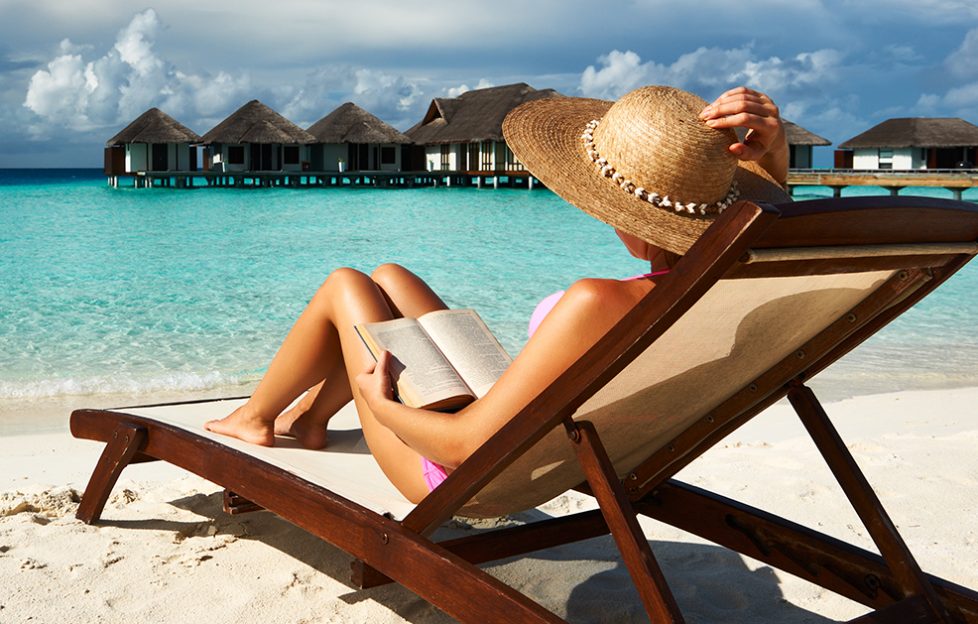 Lady reading a great book on a sunny beach