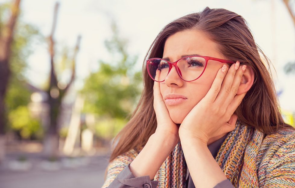 A woman looking thoughtful with hands supporting her head