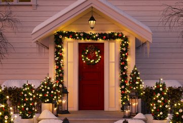 A Christmas decorated front door with snow and lights