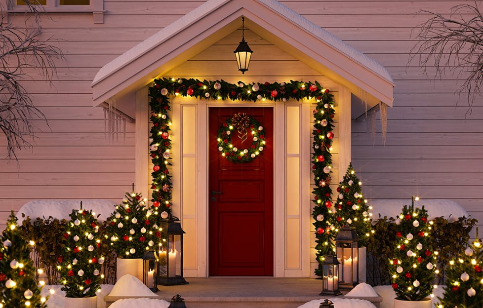 A Christmas decorated front door with snow and lights