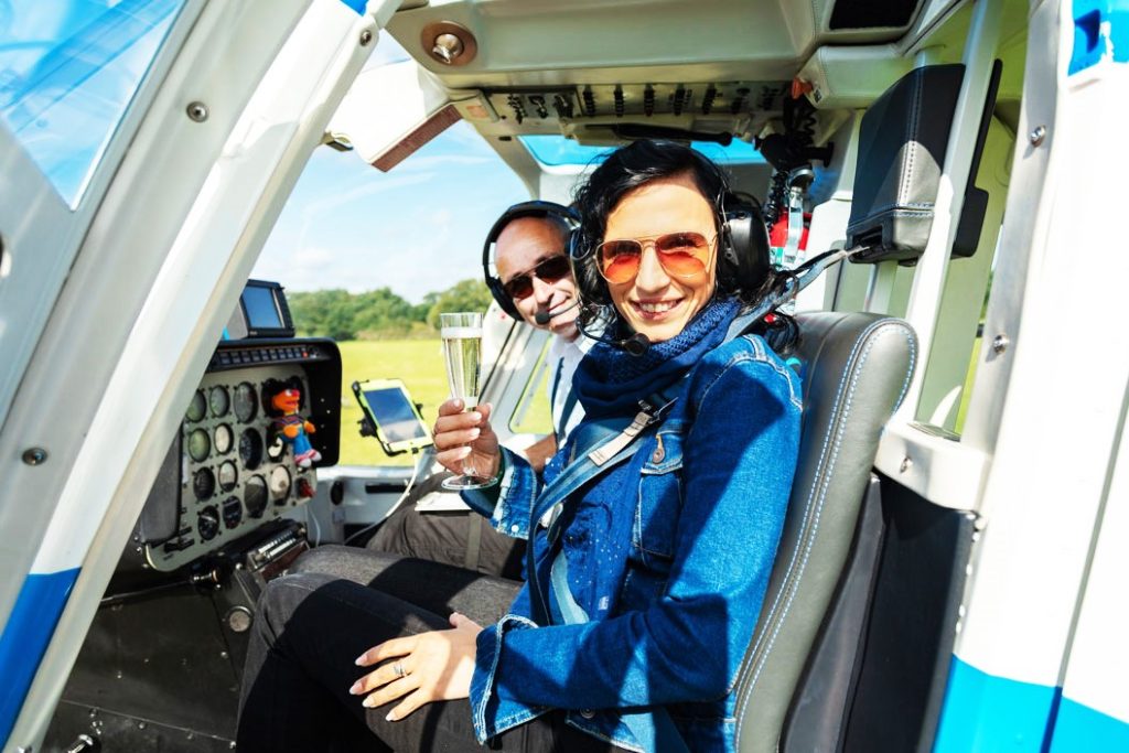 A couple in a helicopter drinking Champagne