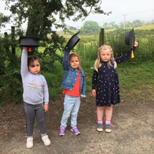 Nursery graduates Naeve McNeill, Arianna Gilchrist and Eilidh Parkhouse preparing to throw their hats in the air.